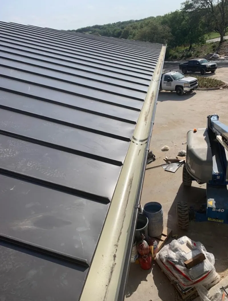 Standing seam panel and gutter detail on a metal roofing jobsite in Surf City